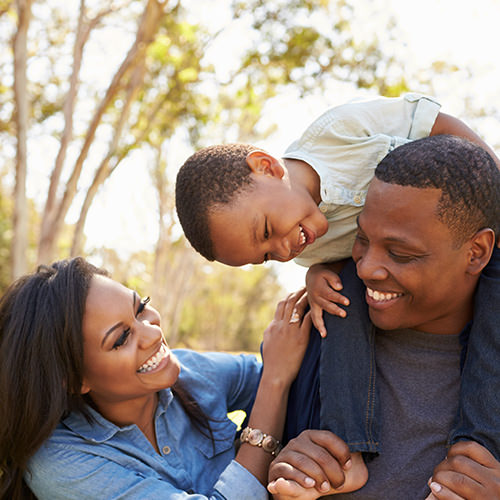 Happy family with young boy on Dad's shoulders