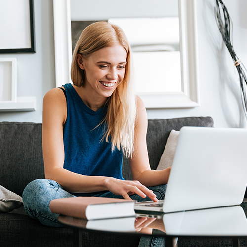 Young woman using a laptop on her sofa