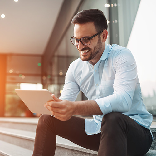 Professional male using a tablet device outside